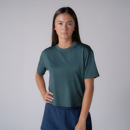 Model wearing a club green colored women's court crop tee shirt.