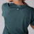 Image of the back side of a club green colored JOOLA women's court crop tee shirt.