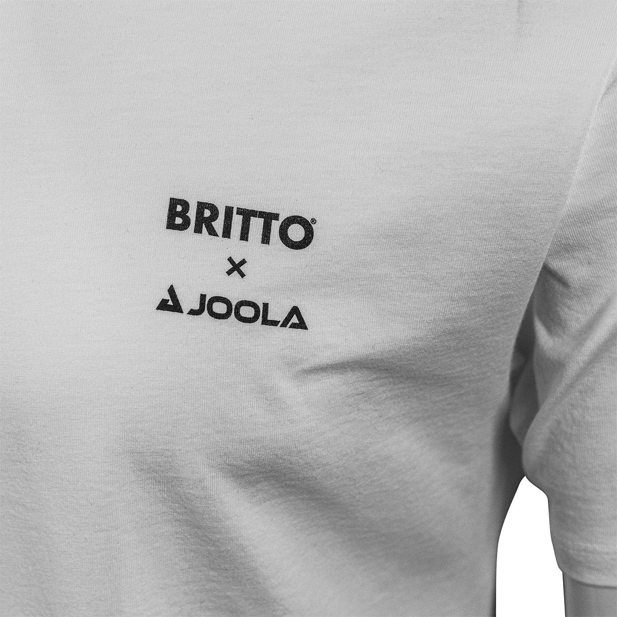 White Background Image: White BRITTO x JOOLA shirt with small BRITTO x Logo on front of the shirt near the right breast.