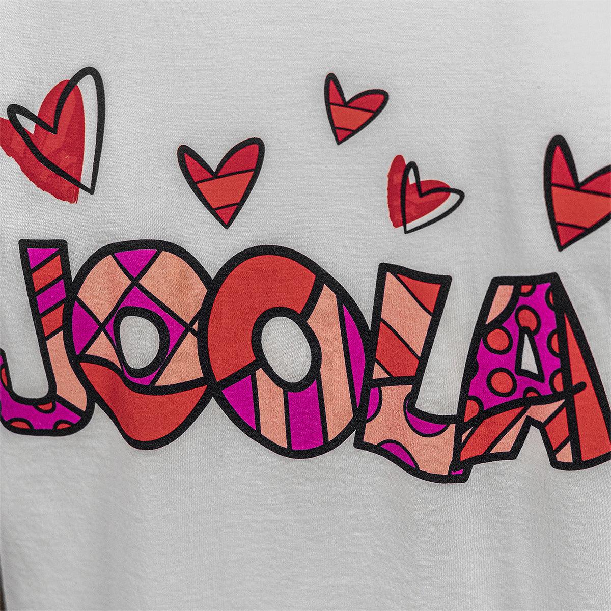 White Background Image: Close up image of the words JOOLA in the art style of BRITTO, red and white hearts.