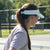 Image of a female model outside on a pickleball court wearing a JOOLA Essential Visor, Gravity Gray.