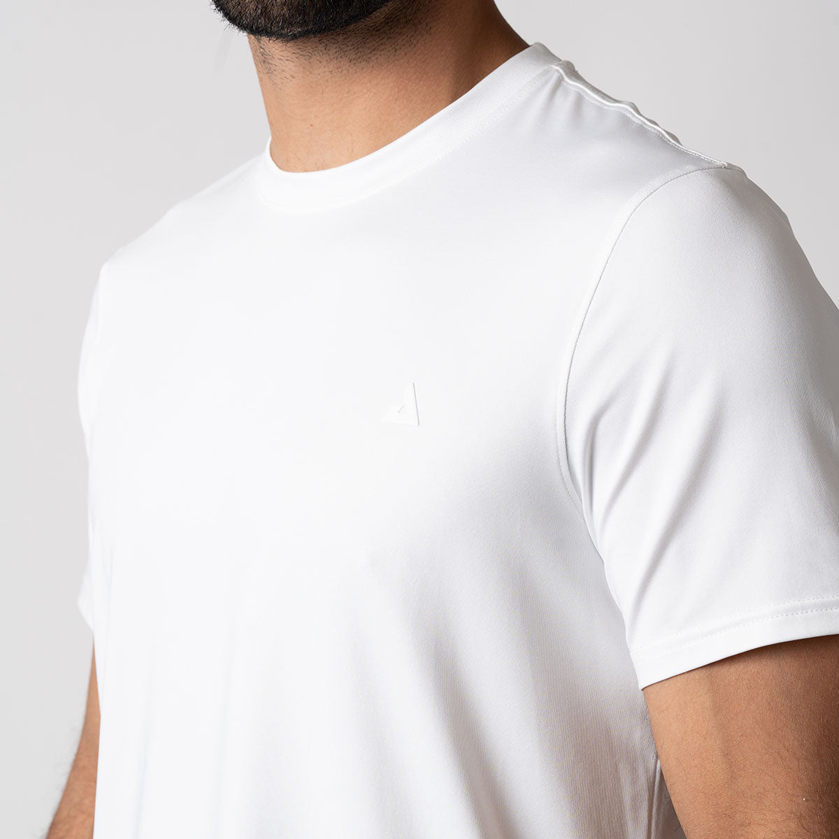 A close up image of the JOOLA Men's Club Short Sleeve Shirt that highlights the Matte 3D heat seal branded JOOLA trinity logo at left side of the chest.