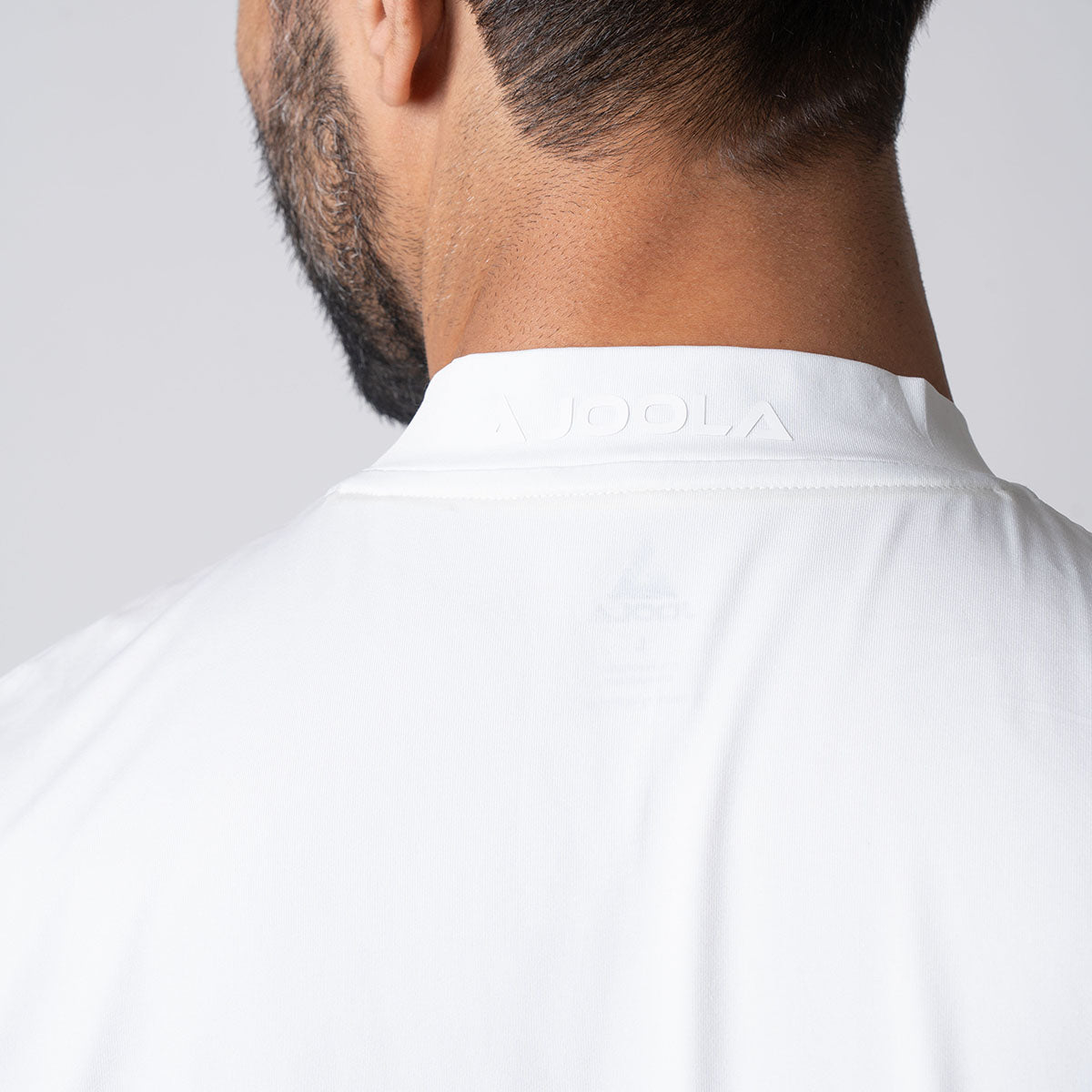 Showing the back of a male model wearing a JOOLA Men's Court Polo, white.