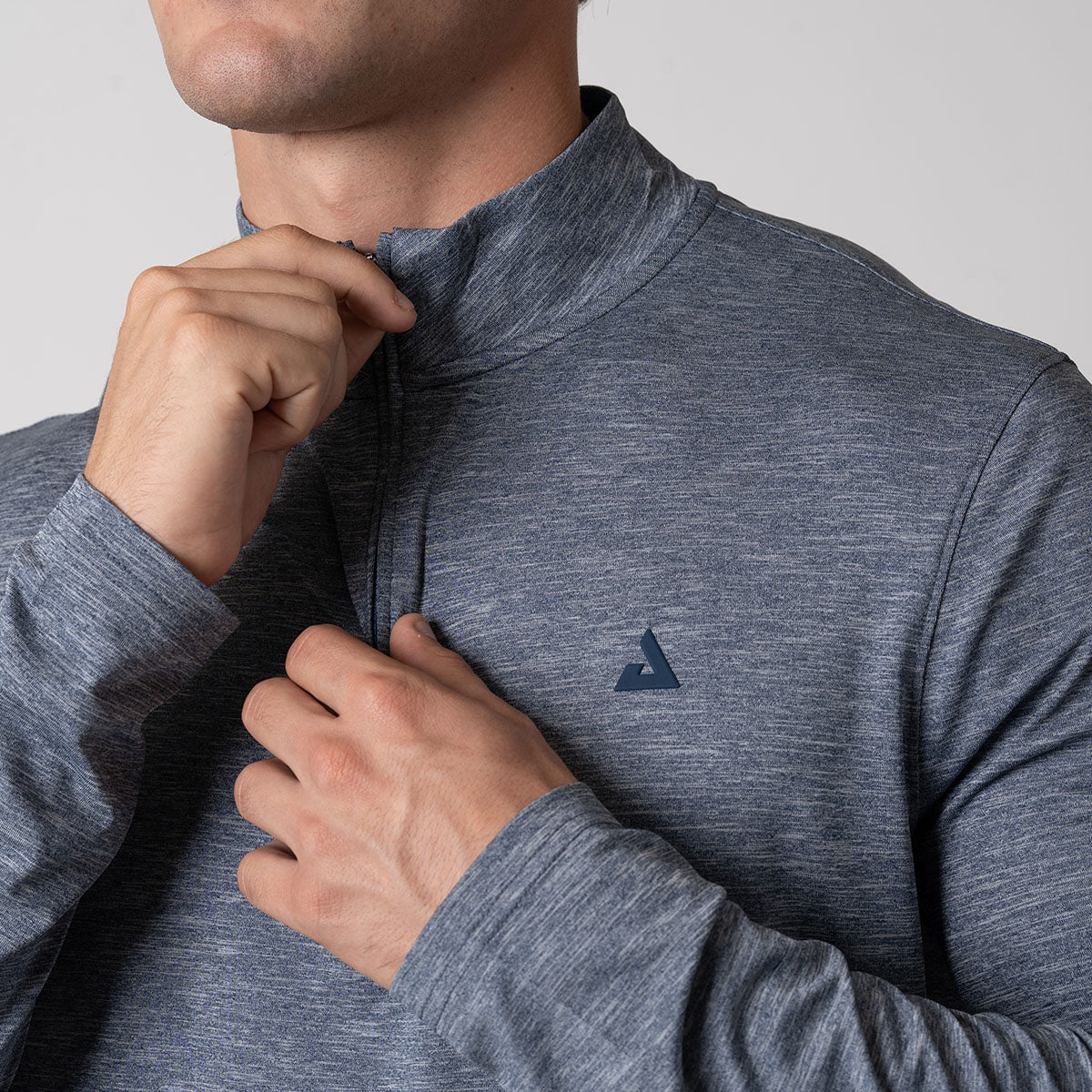 Close up image of a JOOLA Men's Quarter Zip highlighting the quarter zip closure with modern kissing welt, navy heather.