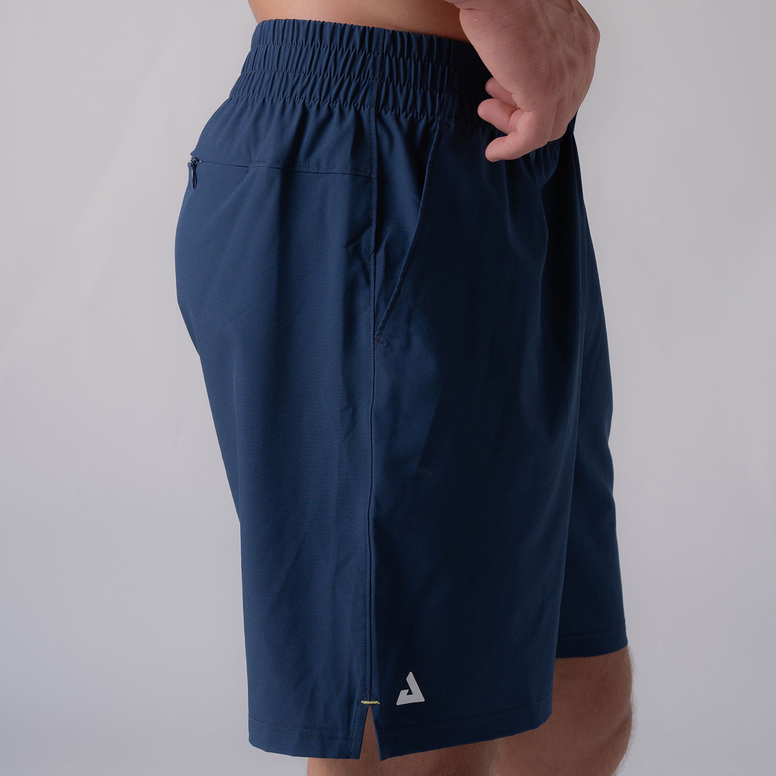 Side profile image of a male model wearing a pair of JOOLA Men's Woven Shorts, Navy.