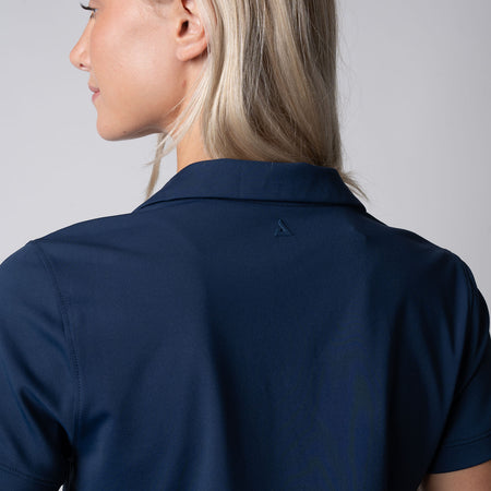 Close up of the back of a female model wearing a JOOLA Women's Club Polo Dress, Navy.