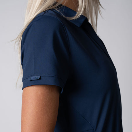 Close up of the Woven JOOLA Label with Printed Logo at Wearer's right sleeve cuff on the JOOLA Women's Club Polo Dress, Navy.