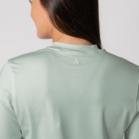 Raised JOOLA Trinity logo between the shoulder blades of a female model who is wearing the JOOLA Women's Quarter Zip Pullover, Hushed Mint.